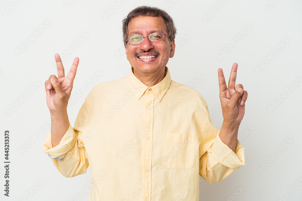 Middle aged indian man isolated on white background showing victory sign and smiling broadly. Middle aged indian man isolated on white background showing victory sign and smiling broadly.