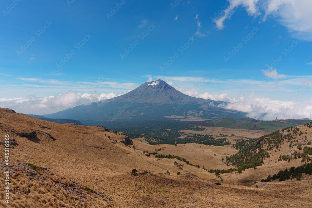 The Popocatepetl volcano with a rocky hill in the foreground The Popocatepetl volcano with a rocky hill in the foreground