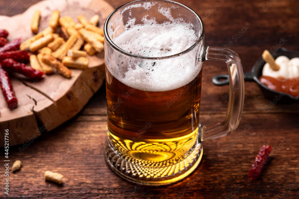 Glass of beer and snacks on a wooden background. Glass of beer and snacks on a wooden background.