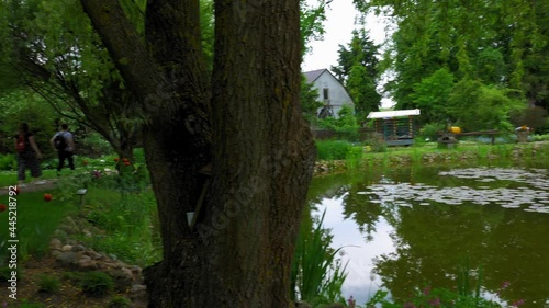 People Touring Around The Garden Of Kaszubska Chata House Museum At Daytime In Brusy-Jaglie, Poland. - Panning Shot photo