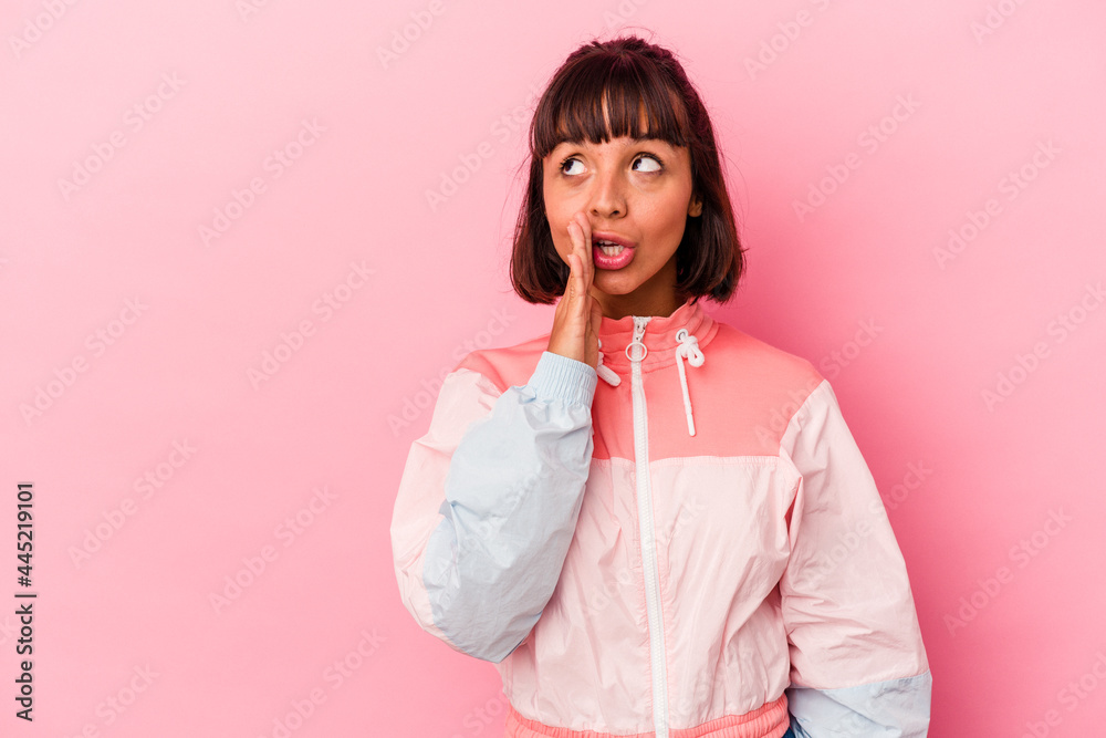 Young mixed race woman isolated on pink background is saying a secret hot braking news and looking aside Young mixed race woman isolated on pink background is saying a secret hot braking news and looking aside