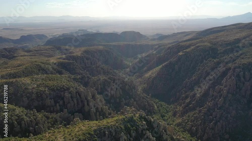 Aerial view of mountains in Arizona during midday. Rock formations can be seen in the Chiricahua National Monument as well as blue skies.