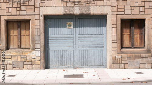 Puerta de garage de madera y ventanas en fachada de piedra photo