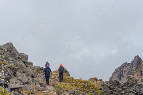 hikers with backpacks climbing the Iztaccihuatl volcano on a misty day