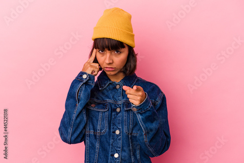 Young mixed race woman isolated on pink background pointing temple with finger, thinking, focused on a task. © Asier