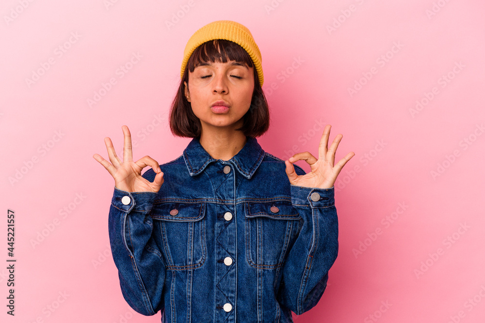 Young mixed race woman isolated on pink background relaxes after hard working day, she is performing yoga. Young mixed race woman isolated on pink background relaxes after hard working day, she is performing yoga.
