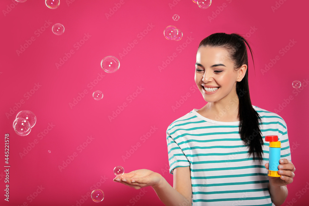 Young woman having fun with soap bubbles on pink background, space for text Young woman having fun with soap bubbles on pink background, space for text
