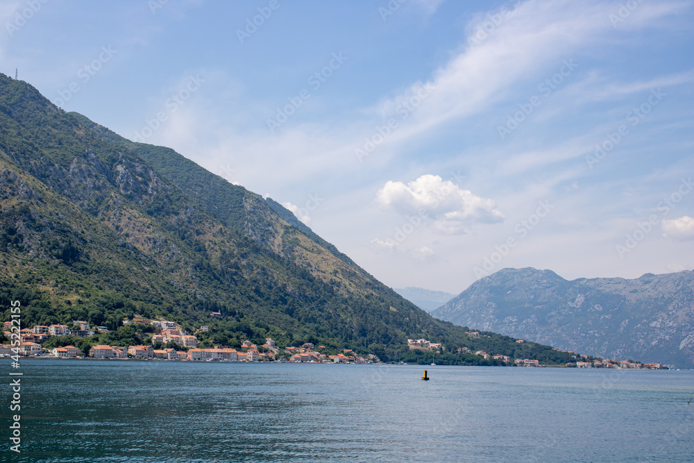 Landscape with blue sea and green mountains against the background of a clear sky. Panoramic beautiful view over the sunny city. Balkans on a wonderful summer day.