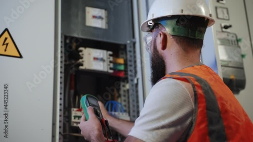 work under voltage, electrician is checking serviceability of equipment