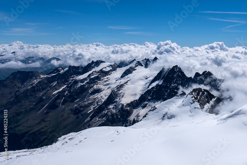 View from the Gran Paradiso summit towards mountains and clouds.