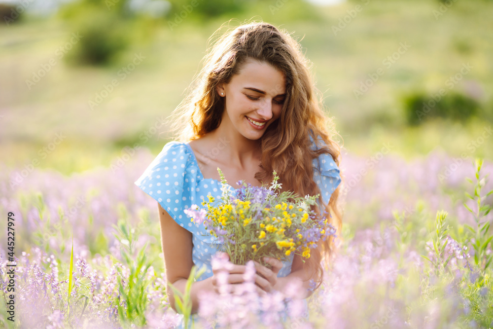 Young woman in stylish summer dress feeling free in the field with flowers in sunshine. Nature, vacation, relax and lifestyle. Summer landscape. Young woman in stylish summer dress feeling free in the field with flowers in sunshine. Nature, vacation, relax and lifestyle. Summer landscape.