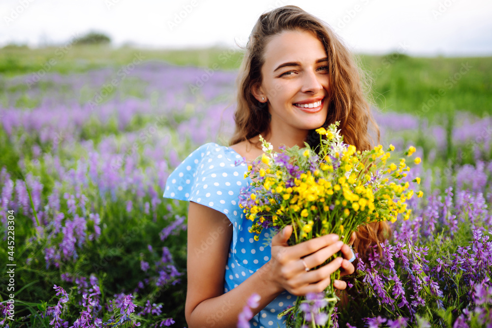 Young woman in stylish summer dress feeling free in the field with flowers in sunshine. Nature, vacation, relax and lifestyle. Summer landscape. Young woman in stylish summer dress feeling free in the field with flowers in sunshine. Nature, vacation, relax and lifestyle. Summer landscape.