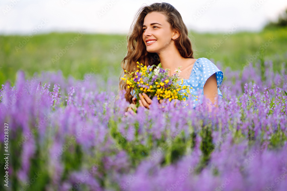 Young woman in stylish summer dress feeling free in the field with flowers in sunshine. Nature, vacation, relax and lifestyle. Summer landscape. Young woman in stylish summer dress feeling free in the field with flowers in sunshine. Nature, vacation, relax and lifestyle. Summer landscape.