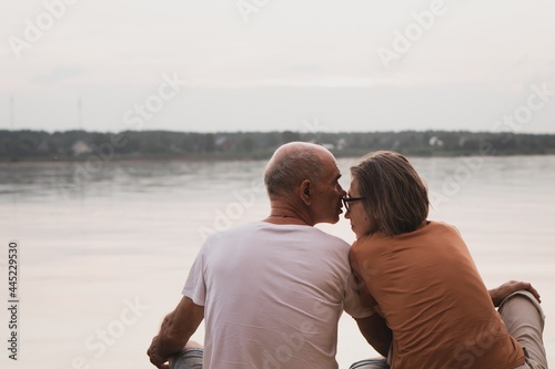 Senior couple kissing on beach in summer evening