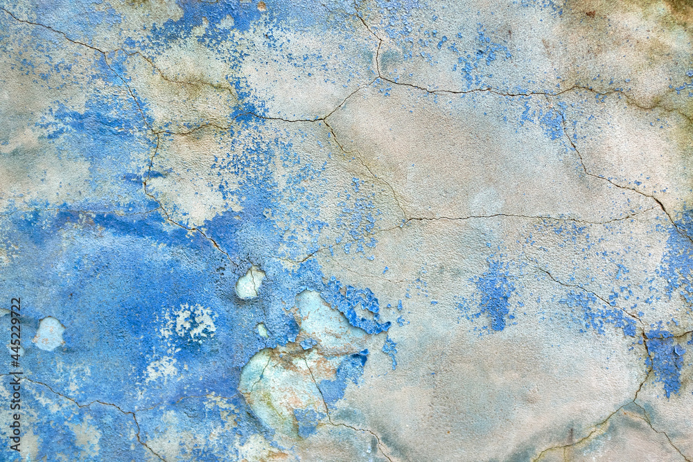 Old paint on the wall with old plaster. Wall with the blue whitewash falling off fragment with cracks as a background texture. Grunge Background, Abstract texture in blue color