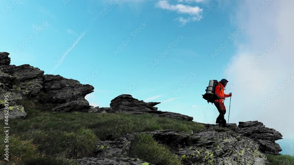 A hiker walking alone on mountain at high altitude A hiker walking alone on mountain at high altitude