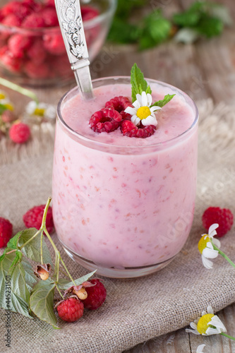 Yogurt with raspberries on wooden table