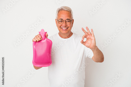 Senior american man holding a hot water bottle isolated on white background cheerful and confident showing ok gesture.