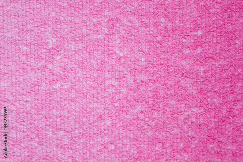 Terry towels of dark red, burgundy color. Textured surface. The color changes saturation with a gradient. The image can be used as texture or background. Copy space.