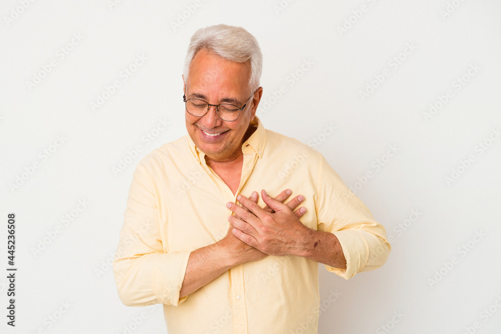 Senior american man isolated on white background has friendly expression, pressing palm to chest. Love concept.