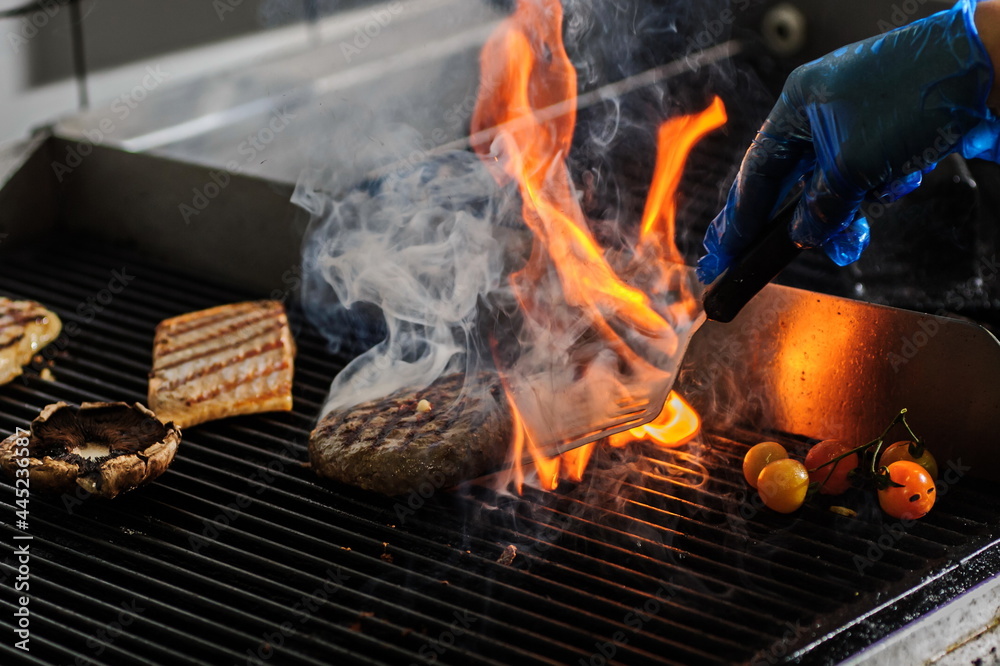 Chef is stirring burger in open fire indoor Chef is stirring burger in open fire indoor