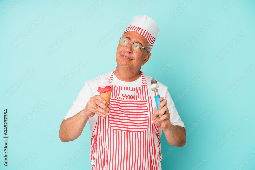Senior american ice cream maker holding an ice cream isolated on blue background Senior american ice cream maker holding an ice cream isolated on blue background