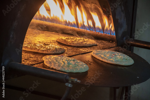 Tabun oven with raw pizzas on it ready to be cooked photo