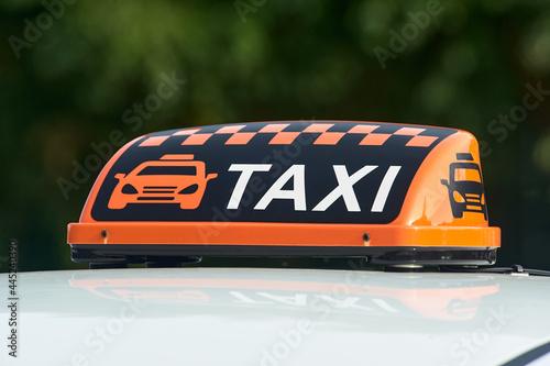 an orange taxi sign stands on the roof of the car