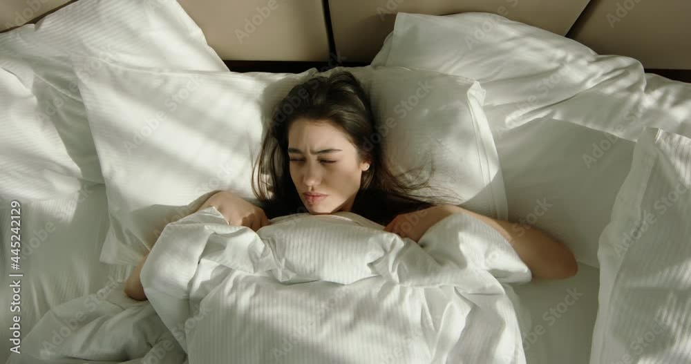 Irritated annoyed teen asian girl waking up early in morning. Teenager suffering from insomnia, frustrated by alarm 4k footage Irritated annoyed teen asian girl waking up early in morning. Teenager suffering from insomnia, frustrated by alarm 4k footage
