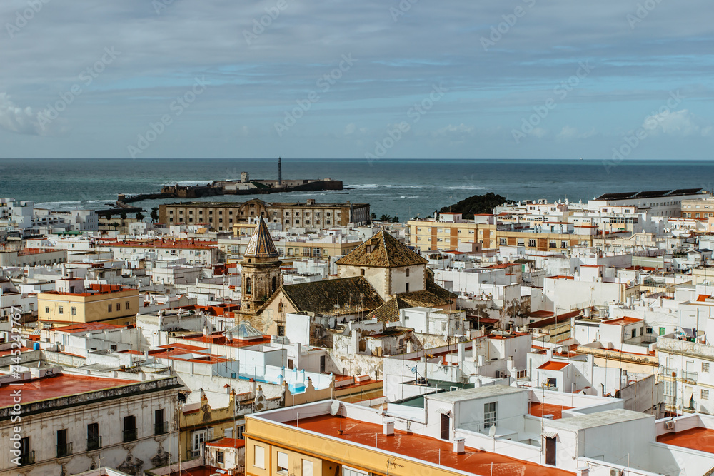 Cadiz, Andalusia, Spain. Aerial panoramic view from Tavira tower of old city with narrow winding alleys, rooftops and seashore on sunny day.European cityscape.Beautiful white city on Atlantic coast.
