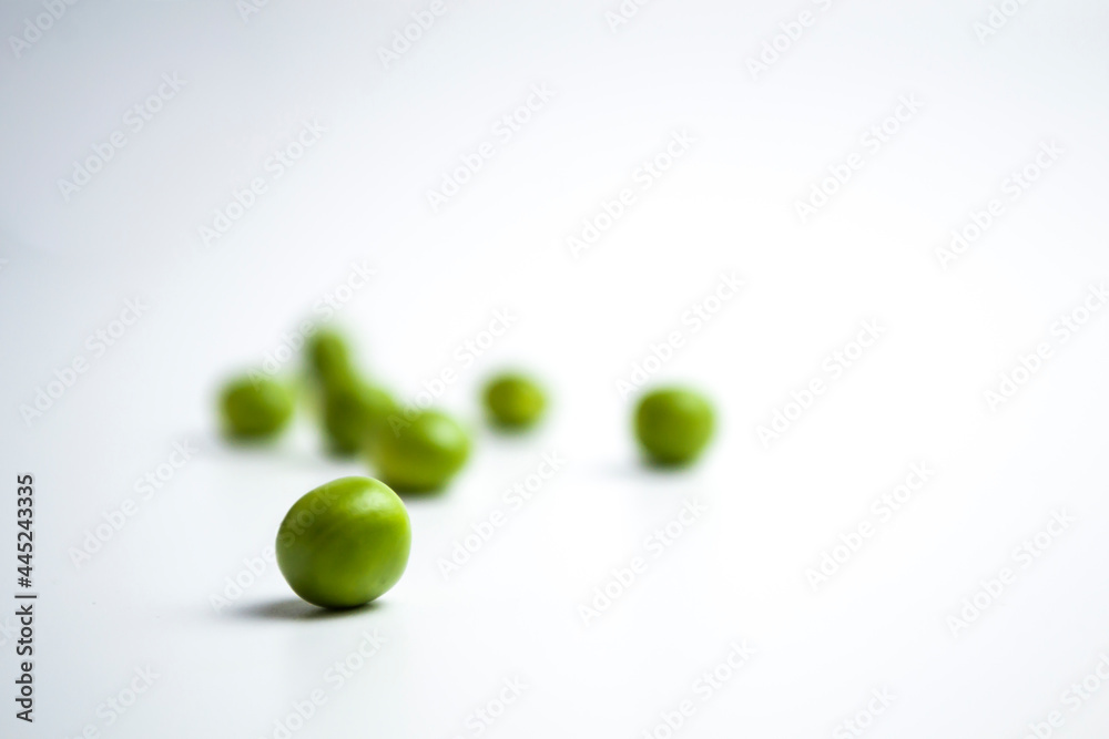 Fresh green peas scattered on a white background. Fresh green peas scattered on a white background.