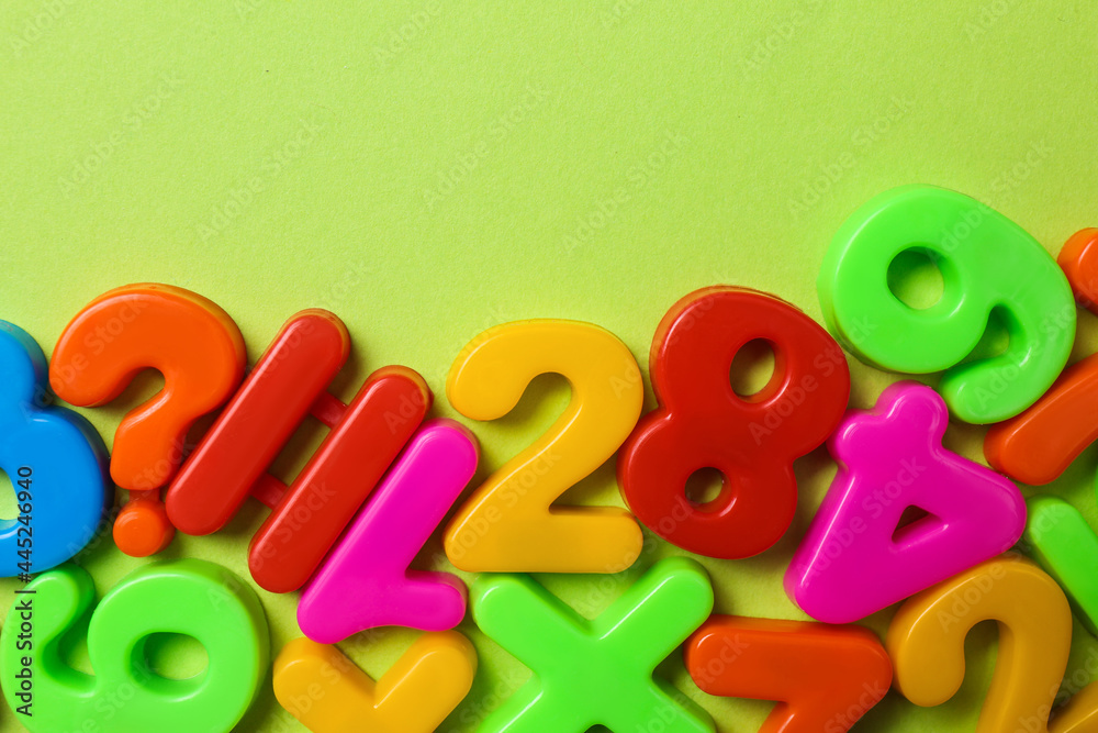 Obraz premium Colorful magnetic numbers on light green background, flat lay