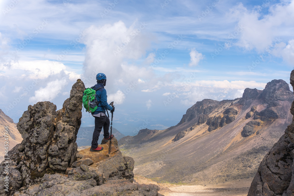 Back view of a hiker with a green backpack on top of the Iztaccihuatl volcano