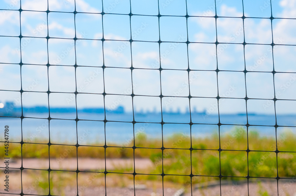 Blurred landscape with river and blue sky through the bars of the gate Blurred landscape with river and blue sky through the bars of the gate