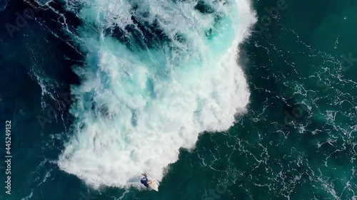 4K drone video of surfers at a beautiful tropical destination with waves