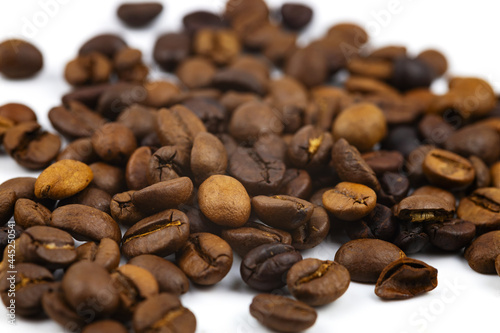 Coffee beans in bulk on a white background. Close-up. Selective focus.