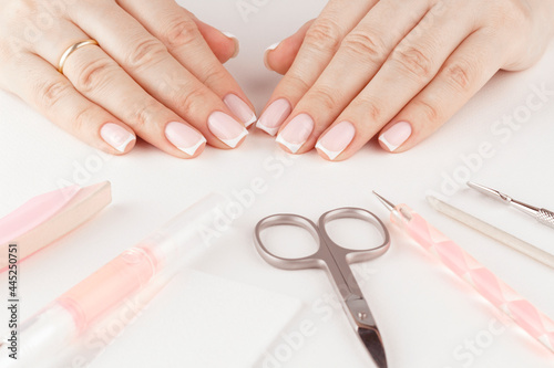 Female hands with pastel trendy French manicure.