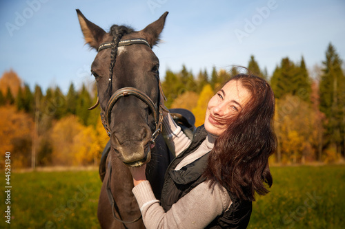 Woman riding a horse in filed in autumn day and blue sky background