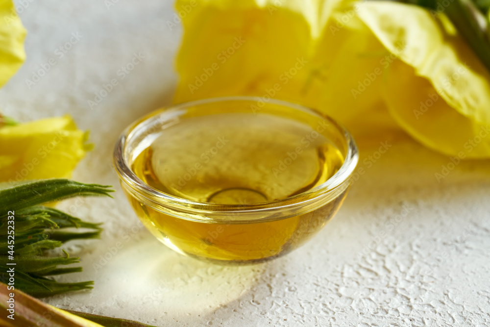 A bottle of evening primrose oil with fresh blooming evening primrose A bottle of evening primrose oil with fresh blooming evening primrose