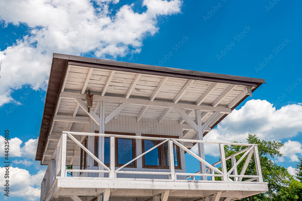White lifeguard booth against blue, cloudy sky White lifeguard booth against blue, cloudy sky