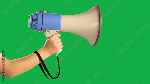 Hand of a man holding a Megaphone on an isolated green background