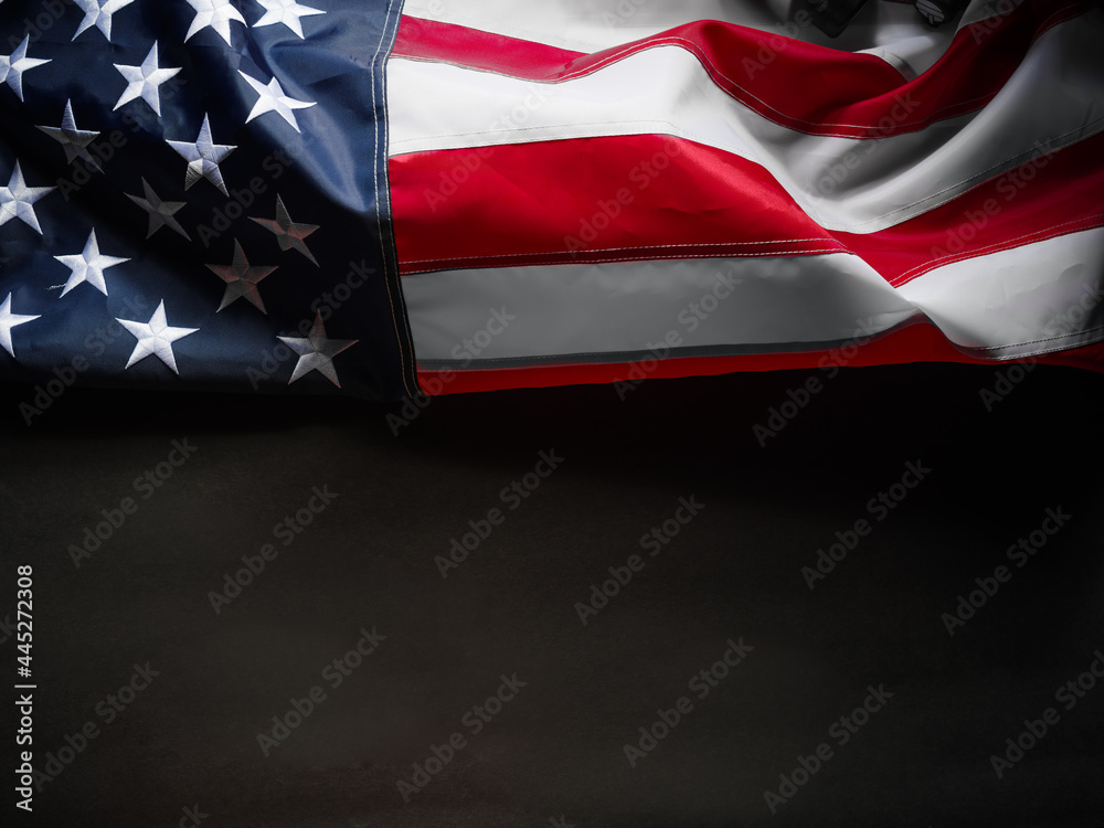 Fototapeta premium American flag. Association with patriotism, pride in their country. Simple black background. There are no people in the photo. There is an empty space for your insert. Close-up.