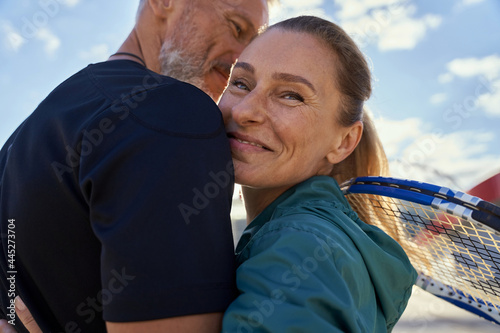 Fotografie Portrait of active mature couple looking happy while embracing each other outdoo