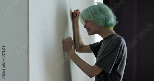 female hits the wall. stressed young woman stands at home, condemning herself and torturing herself, depressed female is crying, no meaning of life, problems in life. People lifestyle, copy space photo