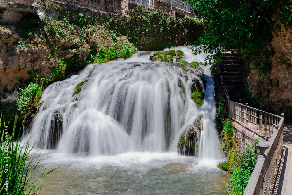 Waterfalls from the Cifuentes river as it passes through the town of Trillo. Wild river. Urban waterfalls.