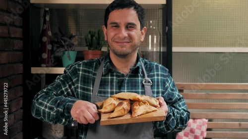 Man cooking empanadas argetinian pie, traditional bakery from argentina, chef filling dough in home with meat and vegetables, homemade spanish empanadas photo