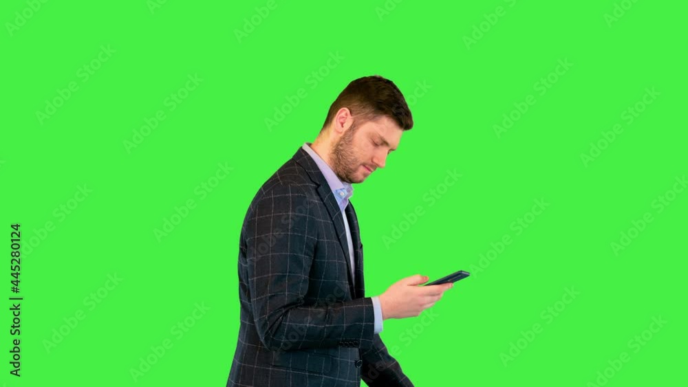 Businessman boss walk focused on message in smartphone texting or browse internet with mobile phone on a Green Screen, Chroma Key. Businessman boss walk focused on message in smartphone texting or browse internet with mobile phone on a Green Screen, Chroma Key.