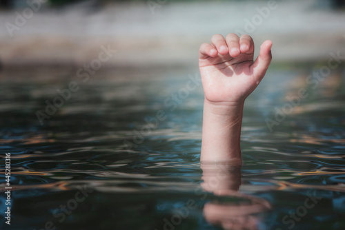 A drowning hand reached out over the surface for help