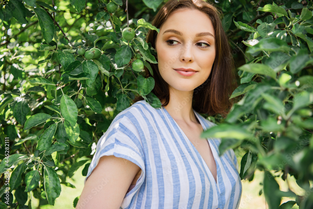 Pretty woman standing near tree branches outdoors Pretty woman standing near tree branches outdoors