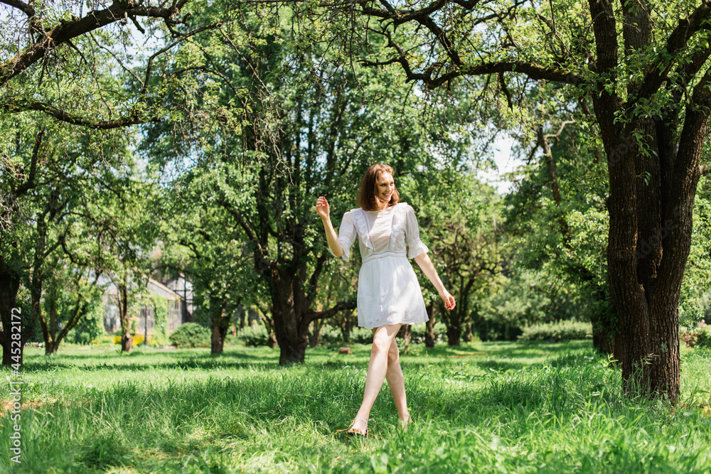 Pretty woman in summer dress walking in park Pretty woman in summer dress walking in park